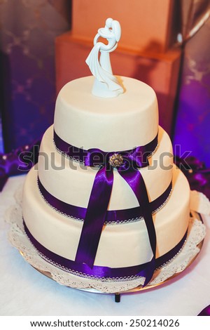 A traditional and decorative wedding cake at wedding reception. three tiered blue and white wedding cake with confectionery roses