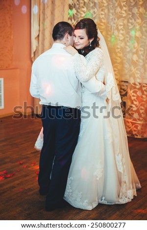 wedding dance of bride and groom. Kiss and dance young bride and groom in dark banqueting hall