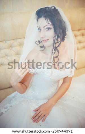Beautiful bride with wedding flowers bouquet, attractive woman in wedding dress. Happy newlywed woman. Bride with wedding makeup and hairstyle. Smiling bride. Wedding day. Gorgeous bride. Marriage.