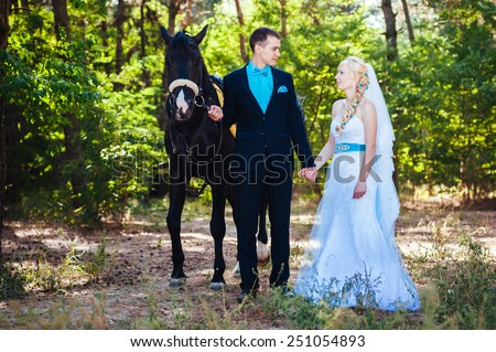 Bride and groom with horse. Portrait of a fashion bride and groom with brown horse.