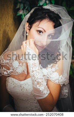 Beautiful bride with wedding bouquet of flowers, attractive woman in wedding dress. Happy newlywed woman. Bride with wedding makeup and hairstyle. Smiling bride. Wedding day. Gorgeous bride. Marriage.