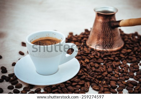 Coffee turk and cup of coffee on burlap background. coffee beans isolated on white background. roasted coffee beans