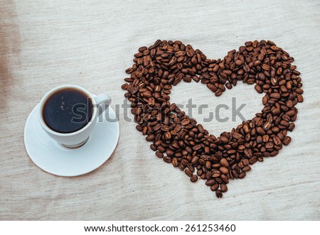 Cup of Coffe. Coffee beans in shape of heart. coffee beans isolated on white background. roasted coffee beans, can be used as a background.