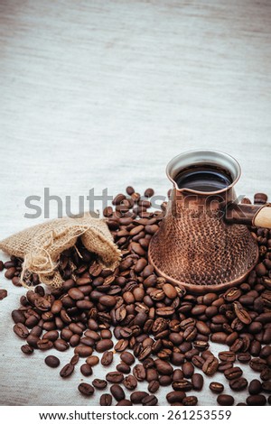 coffee on the table. Cup full of coffee beans on the cloth sack