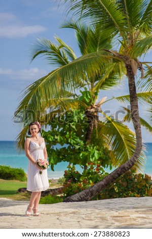happy nice blonde bride walk near beach on green grass under palms. Wild caribbean beach. tropical sand beach in dominican republic. tranquil resort. Palm trees on the tropical beach, Caribbean Sea