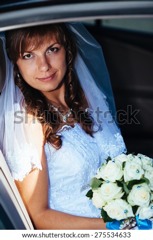 close-up portrait of pretty shy bride in a car window.