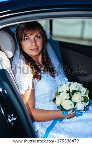 close-up portrait of pretty shy bride in a car window.