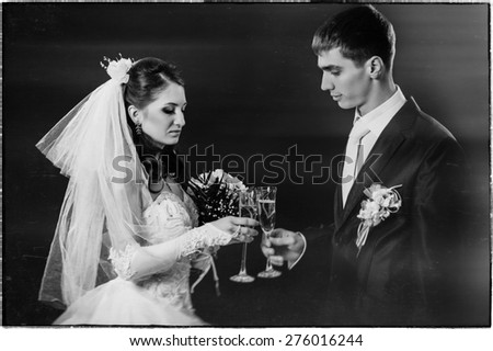 Wedding couple kissing and drinking champagne. Black background. bride groom bouquet drinking champagne wedding dress black studio background