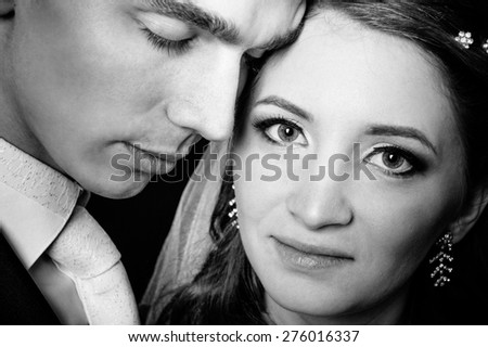 Bride and groom kissing and hugging. wedding photo taken in the studio on a black background.