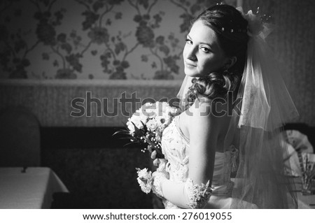 Portrait beautiful bride with bouquet of flowers on luxury interior in wedding day.