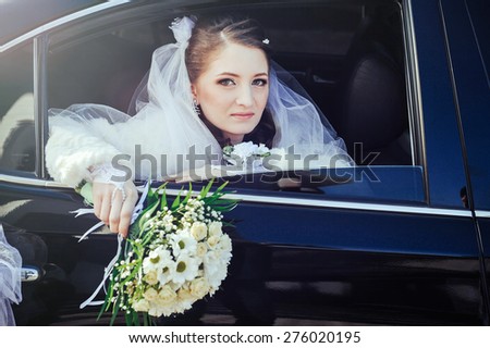 close-up portrait of a pretty shy bride in a car window.