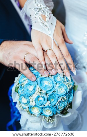 Wedding couple holding hands on wedding bouquet.