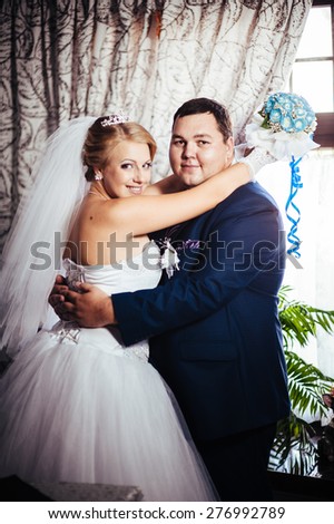 Charming bride and groom on their wedding celebration in a luxurious restaurant. Wedding bouquet of flowers and bridal dress. newly married couple in luxury modern hotel hall.