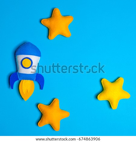 Rocket takes off. Space ship with yellow stars on blue background. Hand made felt toys. Concept for new business project start-up, increase, development, launch of new products, markets.