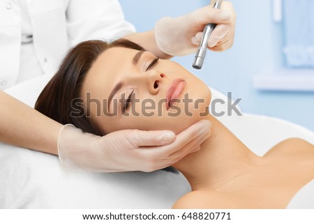 Hardware cosmetology. Spa clinic. Beautiful woman at skin treatment procedure. Microdermabrasion. Young healthy skin. Facial exfoliating. Skin rejuvenation. Beauty treatment. Cosmetology.
