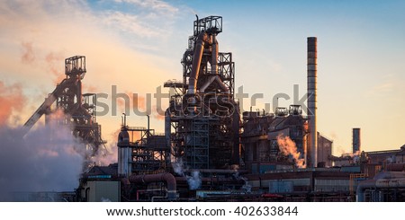 The Tata Steel plant at Port Talbot, South Wales.  Sunset light emphasizing the structures of the plant like pipes and smoke/steam emissions.