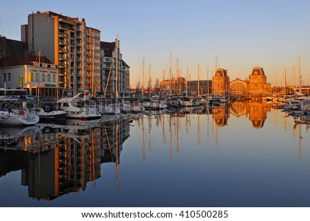The port of Oostende at sunset and its train station bathed in sunlight, Belgium. Translation left: \