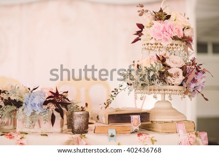 table setting at country wedding reception, floral decoration, wrapped books and candles