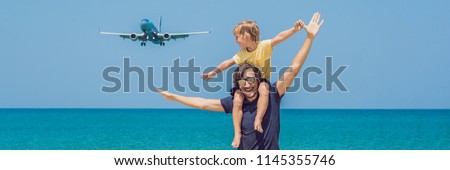 Father and son have fun on the beach watching the landing planes. Traveling on an airplane with children concept BANNER, long format