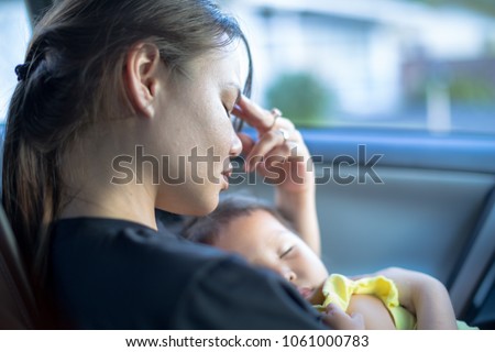 Tired stressed out mother holding her baby