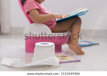 Toddler potty training. reading books on the toilet.