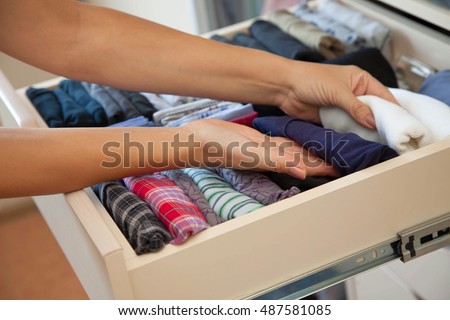 The drawer with underwear in the closet. Men's Clothing lying in the locker room. The order in the men's wardrobe.