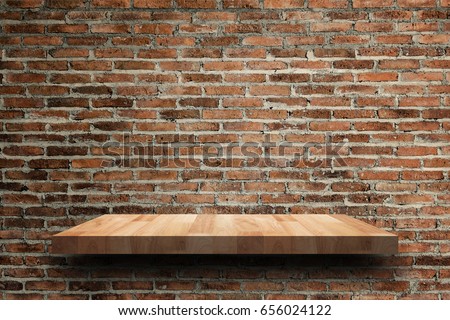 Empty wooden shelf on old brick wall texture. For display or montage your products with focus wooden shelf top in the foreground. Empty wooden brown shelf. shelves