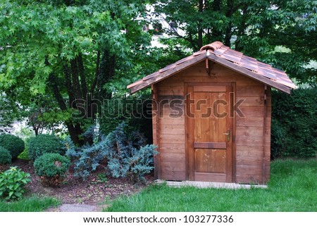 Wooden garden tool shed in a beautiful park - stock photo
