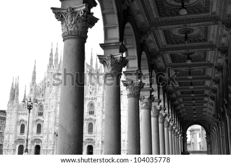 Black and white picture of ancient arcade and gothic cathedral of Milan, Lombardy, Italy