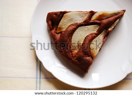 One slice of homemade chocolate cake with sliced pears on the top