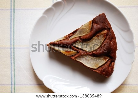 One slice of homemade chocolate cake with sliced pears on the top