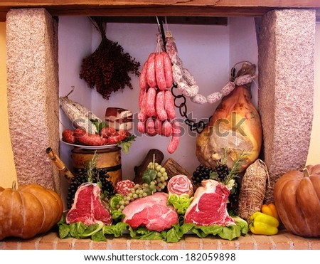 Composition of italian cold cuts and meat in an old fireplace