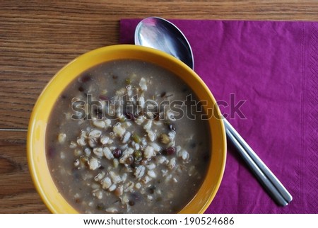 Barley soup with mixed beans flavored with miso in an orange bowl