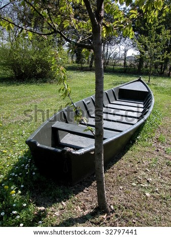 Old boat sailing over spring grass and flowers