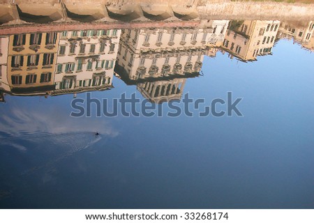 Ancient houses reflecting into the water on Arno river, Florence, Italy