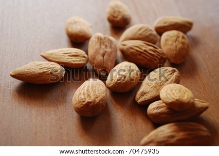 Shelled almonds on natural wooden table background