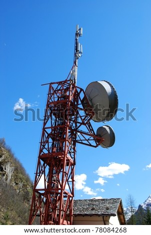 Huge communication antenna tower and satellite dishes against blue sky