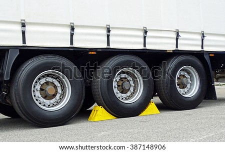Yellow chocks at the wheel of a truck-trailer
