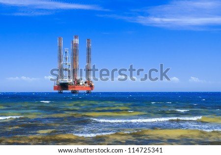 Offshore oil rig drilling platform in the sea against the blue sky