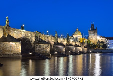 Vltava river, Charles Bridge and Old Town Bridge Tower in Prague at night against a blue sky. Karluv Most. Czech Republic