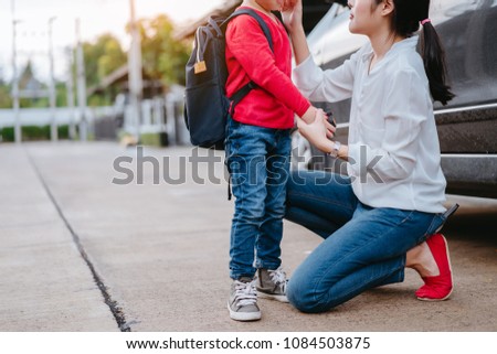 Mother dressing up a son and sending to school, Parent and pupil going to kindergarten of preschool first day back to school concept.