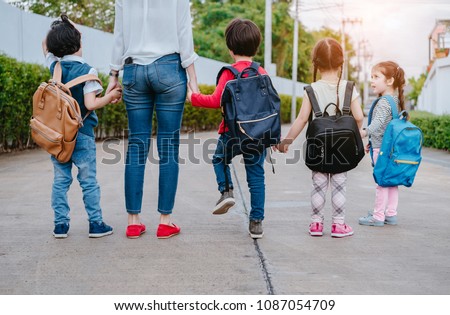 Mother and pupil and kids holding hands going to school in first class with schoolbag or satchel walking to school bus, Parent and son,sister preschool