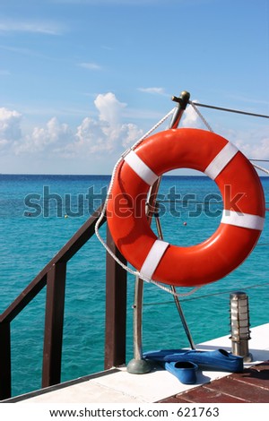 Life preserver stands at the ready. a pair of flippers were left behind by a person snorkeling