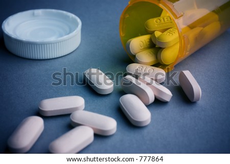Drug abuse or medical concept image: Pills spilled from bottle.