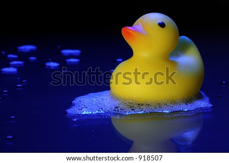 Rubber ducky swimming in a pool of foamy water.