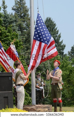 ANN ARBOR, MI - MAY 27: Unidentified boy scouts raise the flag at the Memorial Day observance on May 27, 2012 at Arborcrest Memorial Park in Ann Arbor, MI