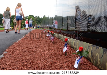 HAMBURG, MI - AUGUST 30: Visitors walk past the traveling Moving Wall Vietnam War memorial exhibit in Hamburg, MI on August 30, 2014.