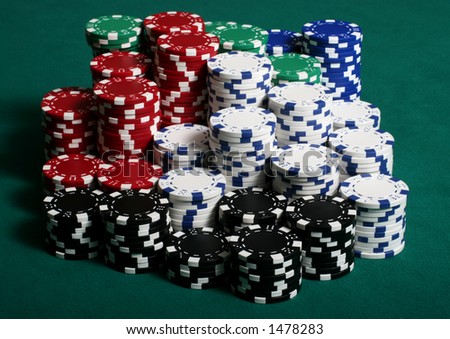 Large amount of poker chips stacked on a green felt pokertable