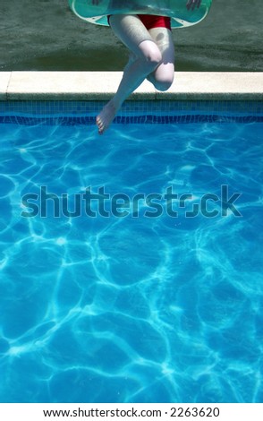 Young woman jumps into a swimming pool on a hot summer day - perfect for generic holiday and travel usage such as spring break