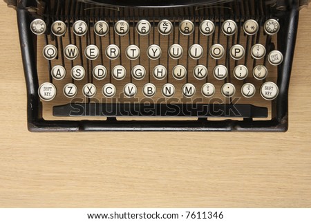 Retro typewriter with qwerty keyboard on a wooden desk